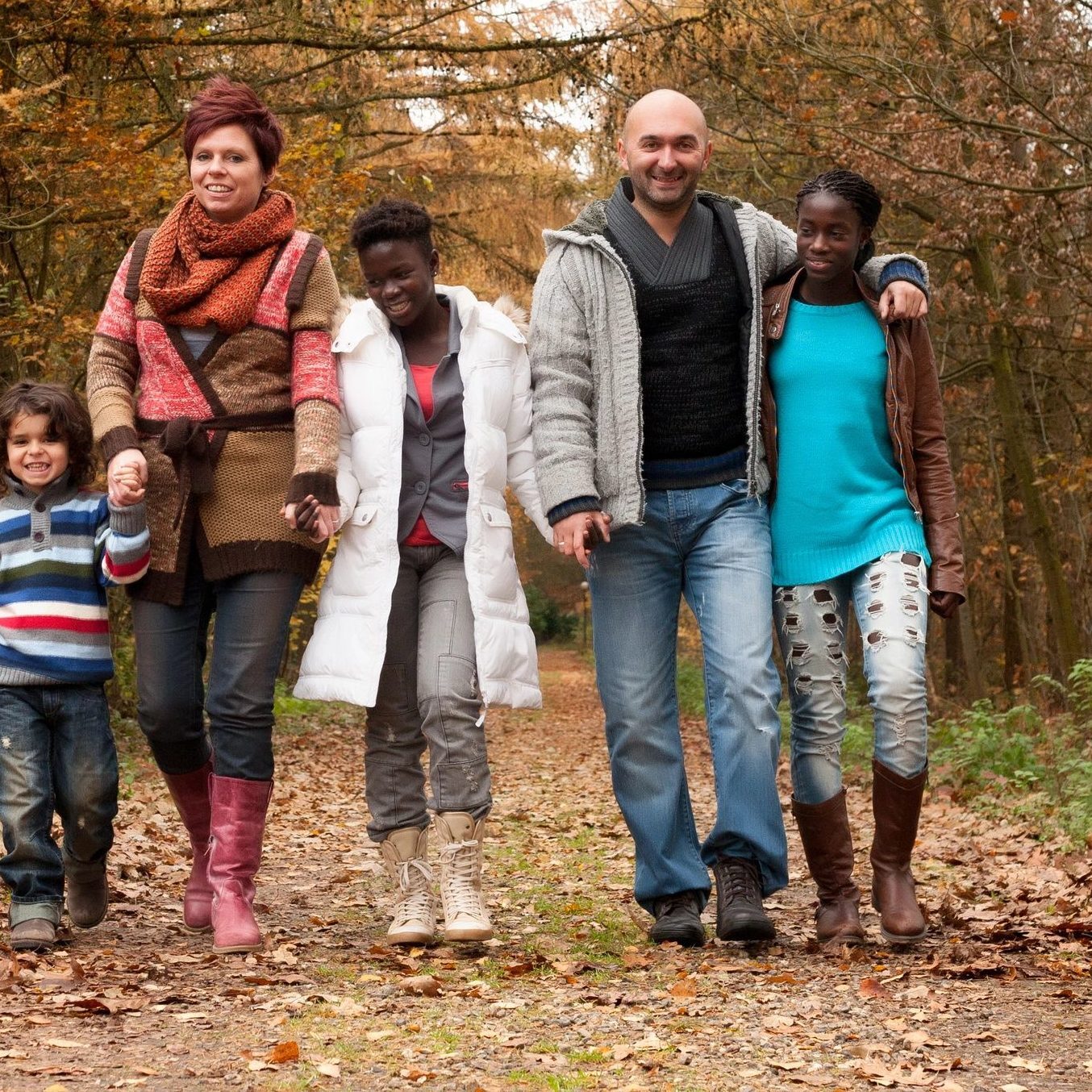 group of people walking on a wooded path